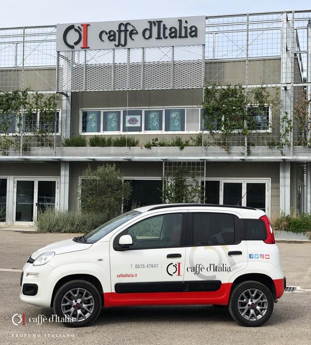Een auto van Caffè d'Italia vlak voor een fabriek in Toscane