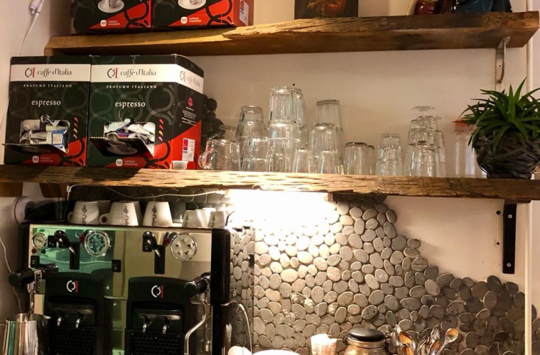 Een horeca koffie machine op een aanrecht in een keuken met koffiespullen