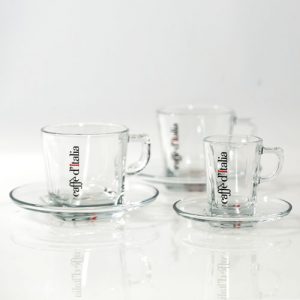 Glazen kopjes en schotels met Caffè d'Italia logo op een glazen blad