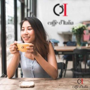 Aziatische dame kijkt naar buiten geniet van een heerlijke kop koffie aan tafel